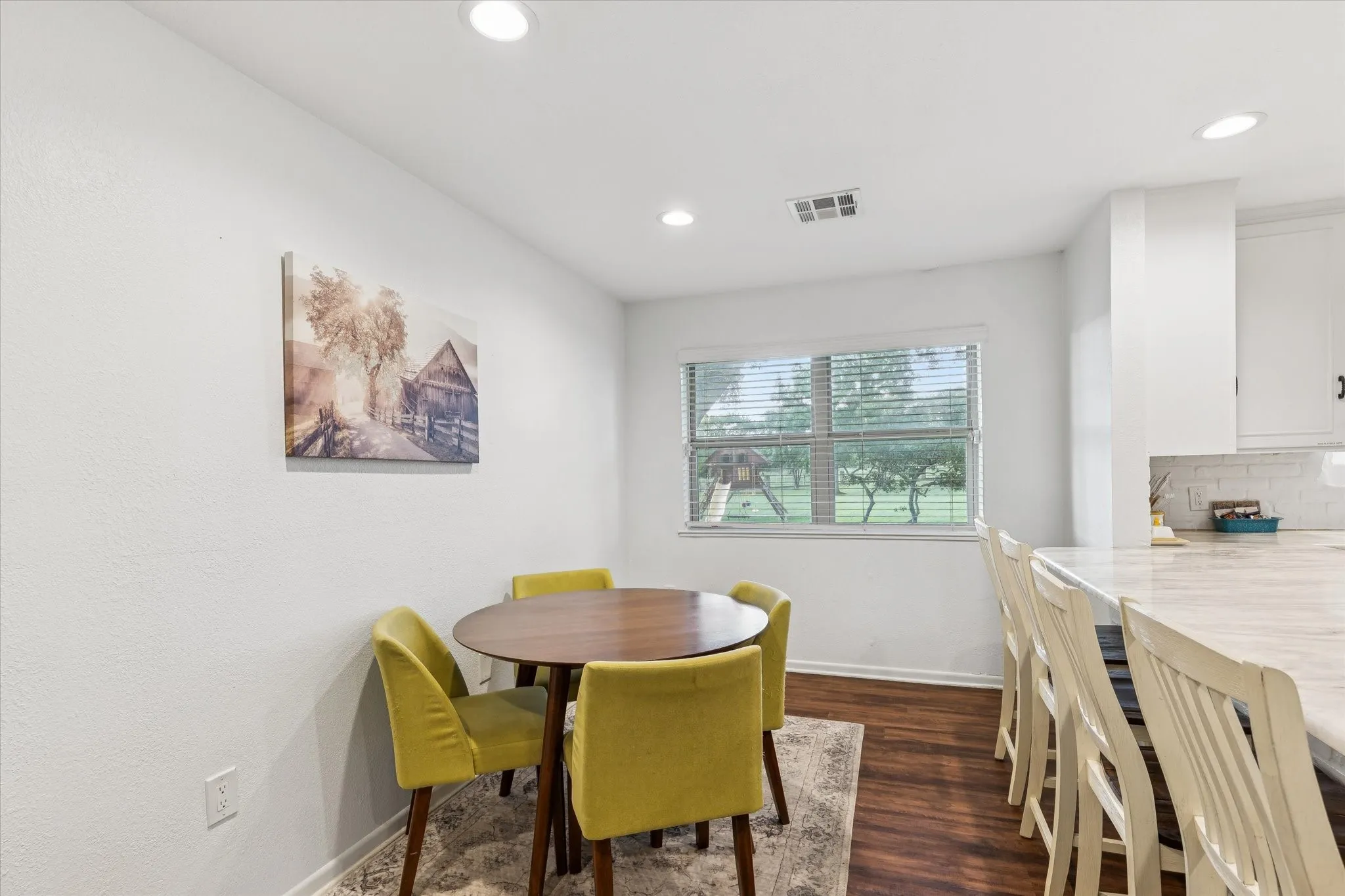 Dining area with dark wood-type flooring and recessed lighting