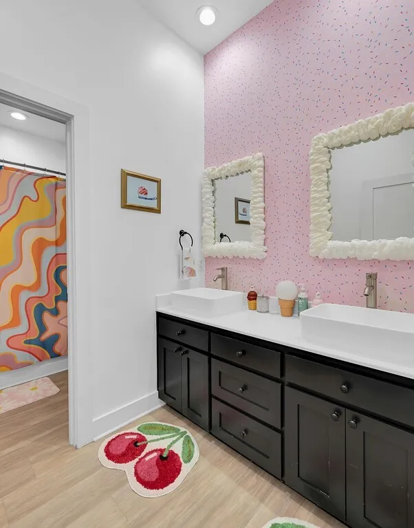 Bathroom with double vanity, light wood-style floors, a shower with shower curtain, and recessed lighting