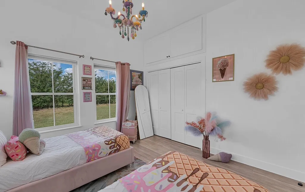 Bedroom with wood finished floors, a chandelier, and a closet