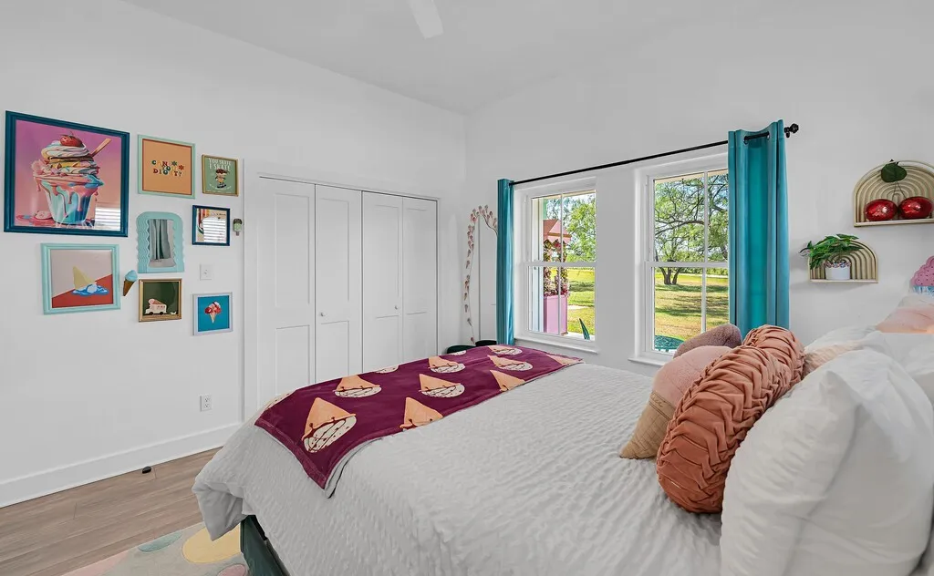 Bedroom with wood finished floors, a ceiling fan, and a closet