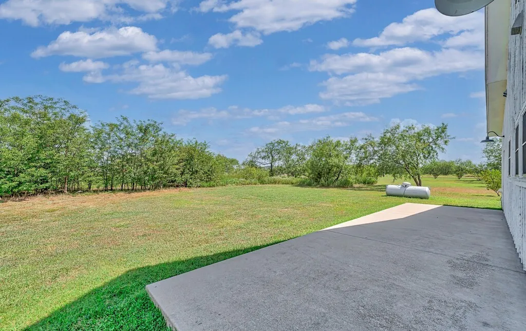 View of green lawn featuring a patio