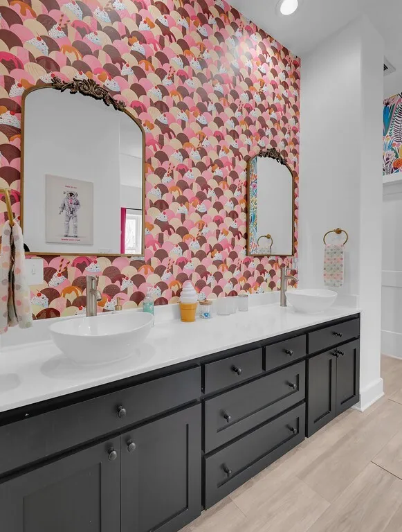 Bathroom with double vanity, wallpapered walls, and recessed lighting