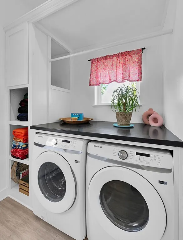 Laundry room featuring washer and dryer and light wood-type flooring
