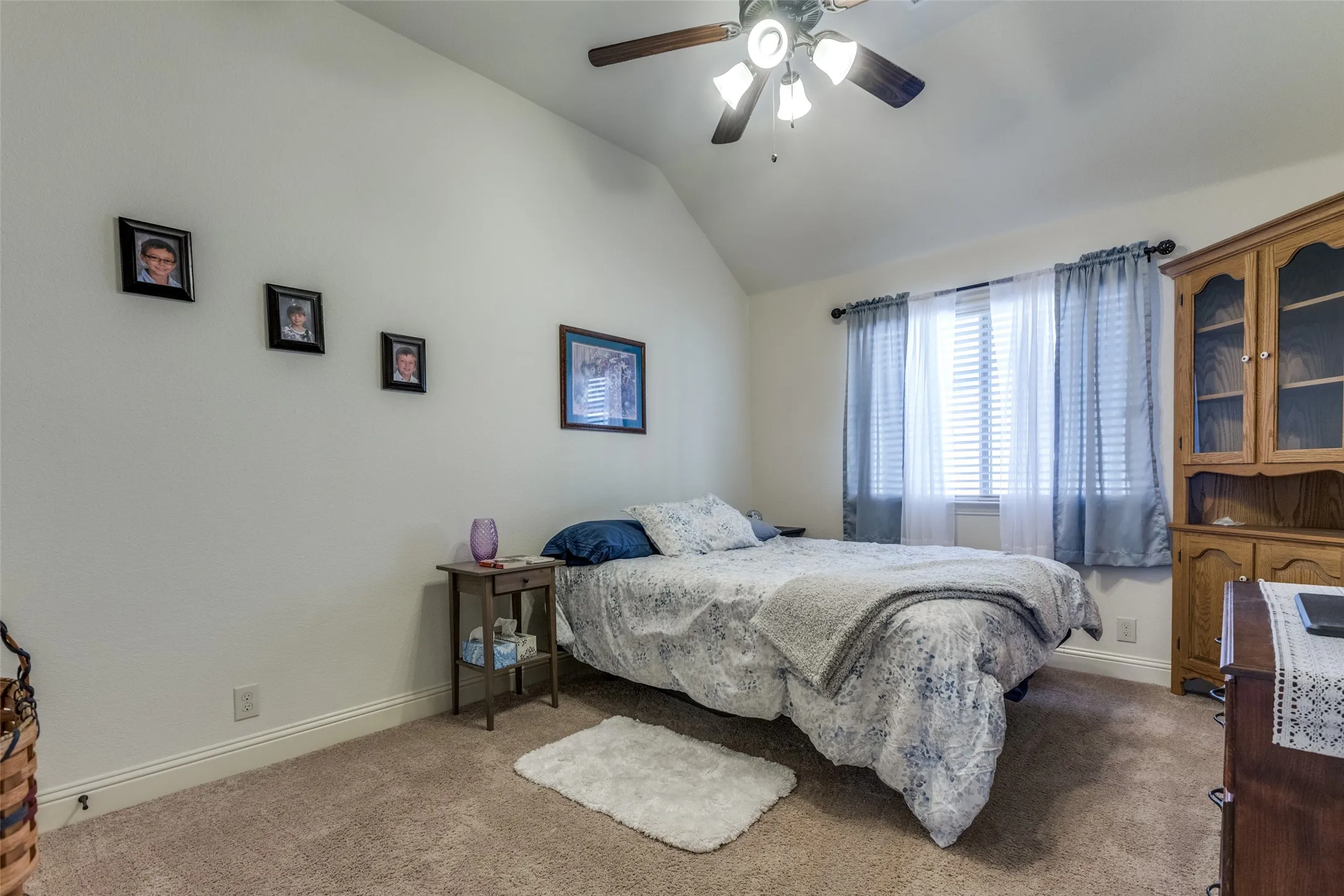 Bedroom featuring carpet flooring, lofted ceiling, and a ceiling fan