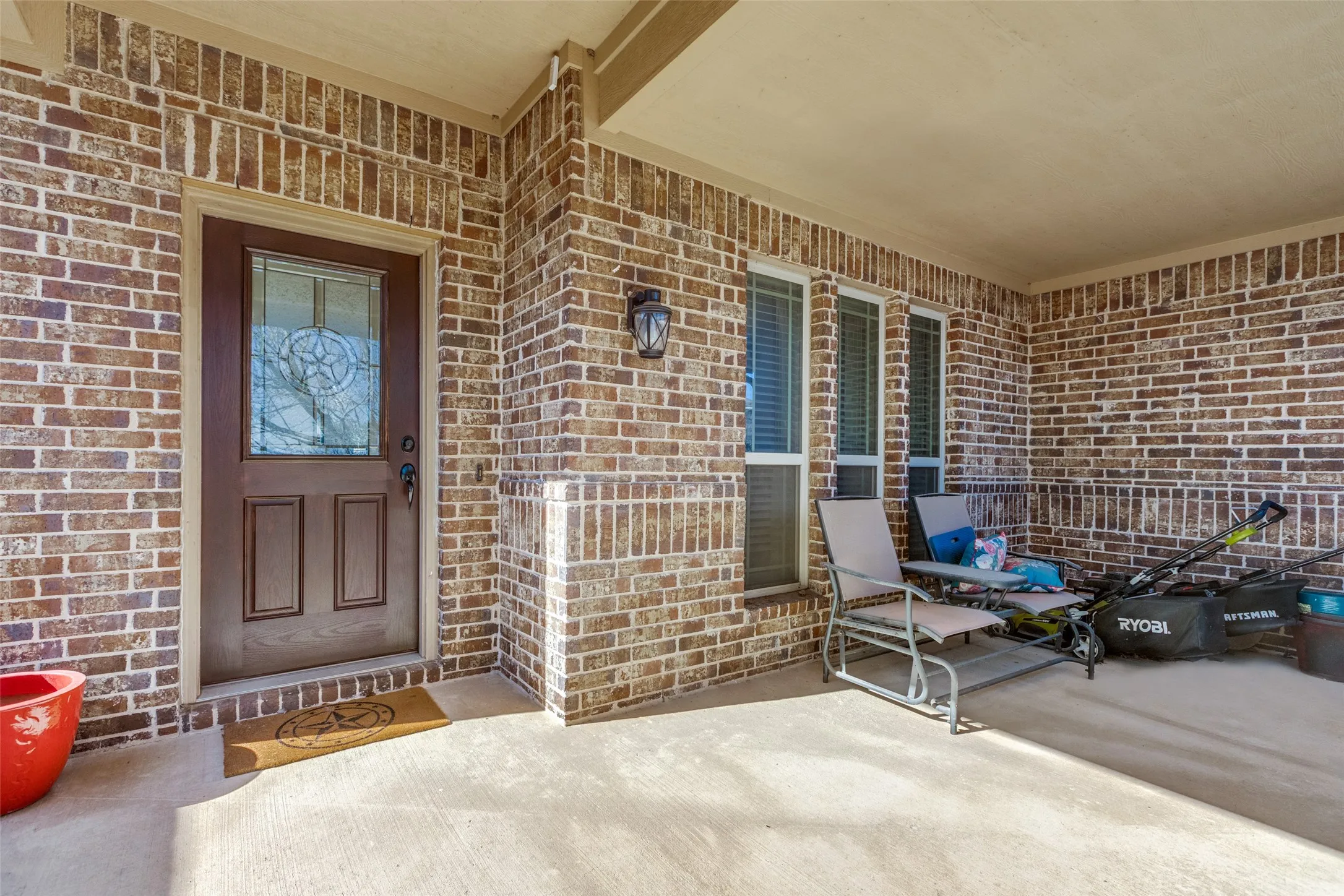 Entrance to property featuring brick siding and covered porch