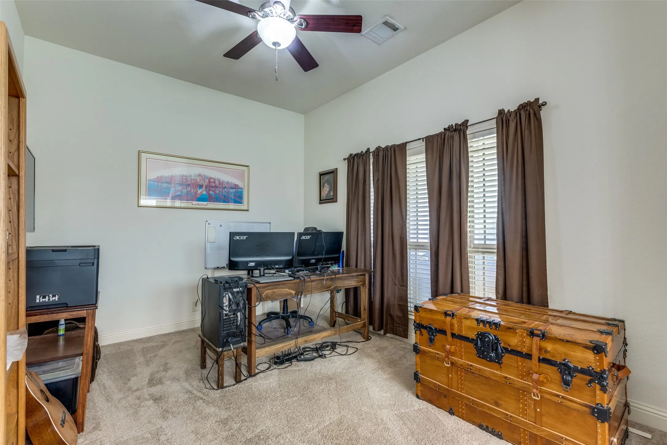 Carpeted home office with baseboards and a ceiling fan