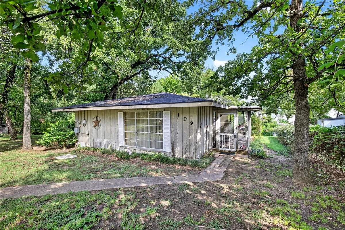View of side of property featuring view of wooded area