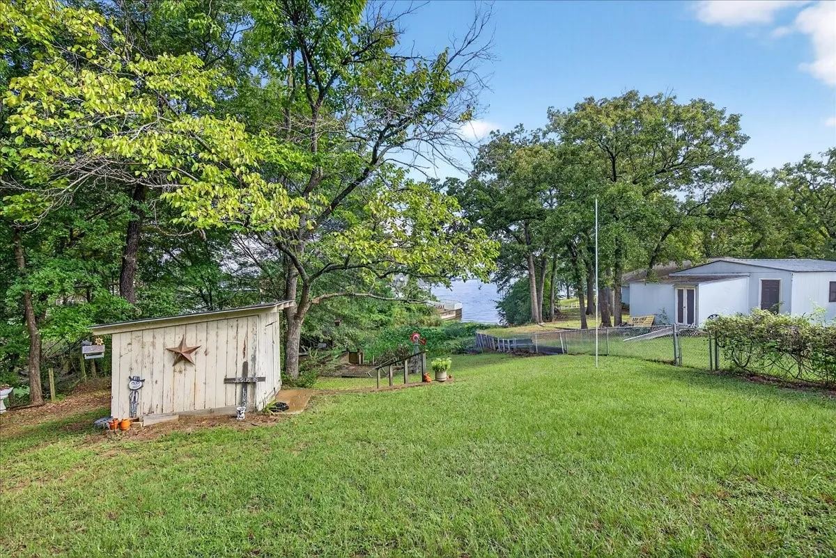 View of yard featuring a storage unit and view of wooded area
