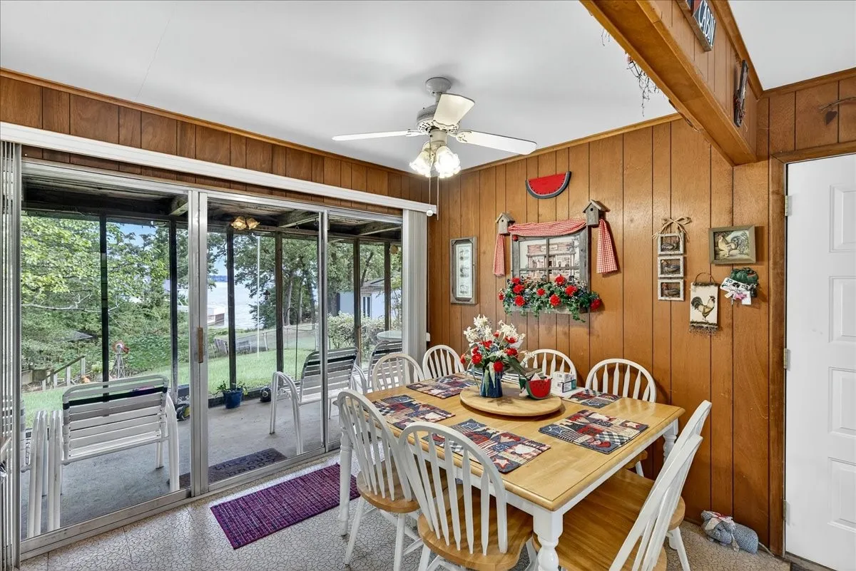 Dining area with wood walls and ceiling fan