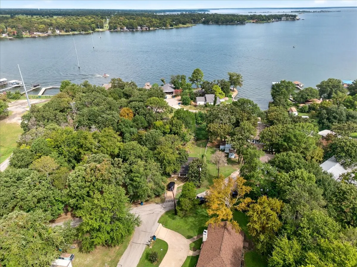 Aerial overview of property's location with a large body of water and a tree filled landscape