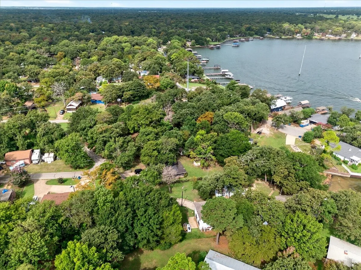 Aerial overview of property's location featuring a nearby body of water and a forest