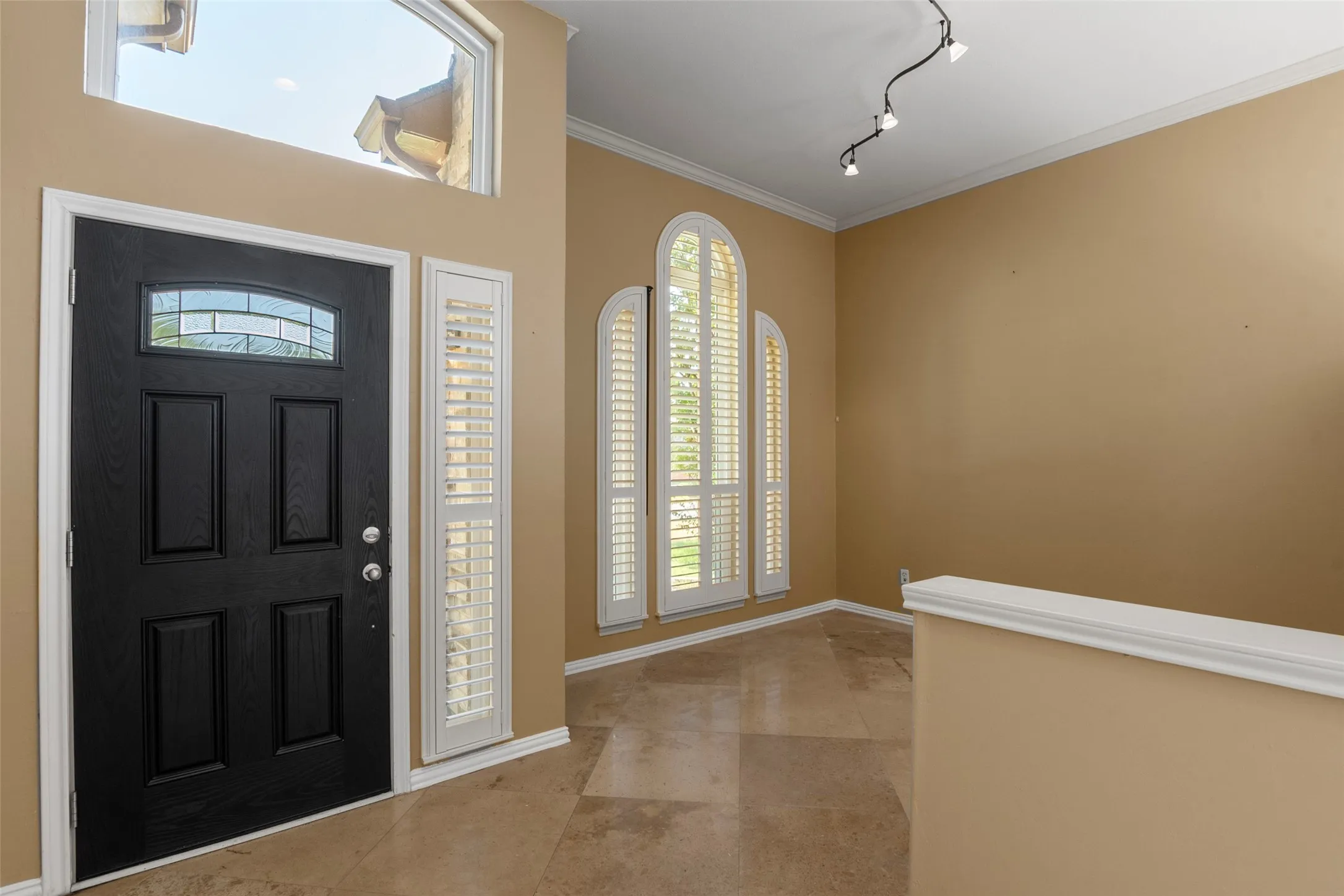 Entryway with a black paneled door, decorative glass transom, and side lite
