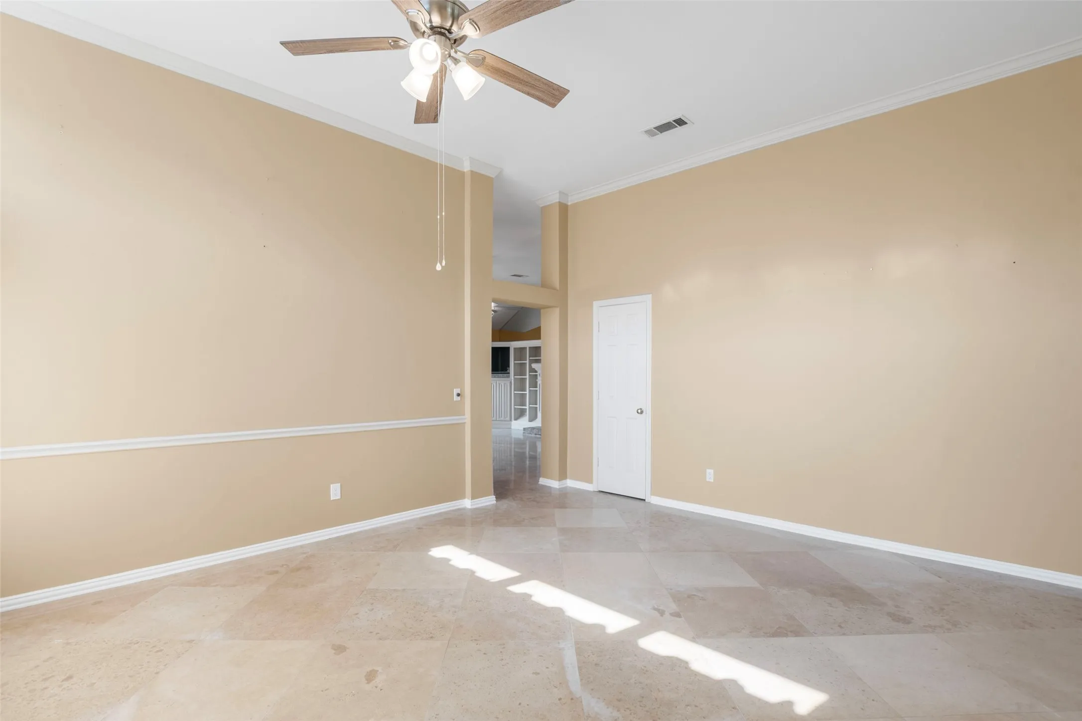 Vaulted ceiling with a ceiling fan, crown molding, wall trim, and tiled flooring