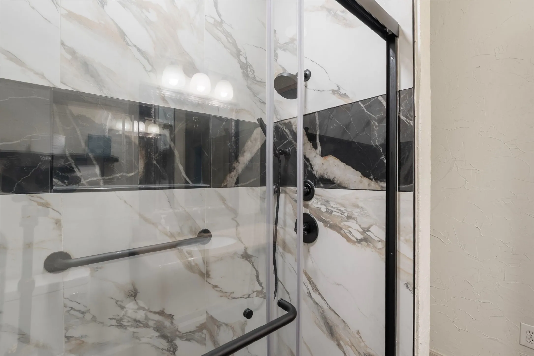 Shower enclosure with clear glass paneling and a matte black frame