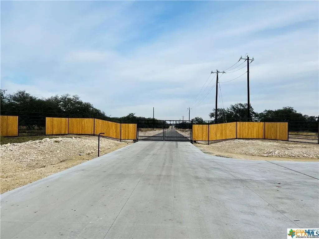 View of concrete surface featuring a gate and a gated entry