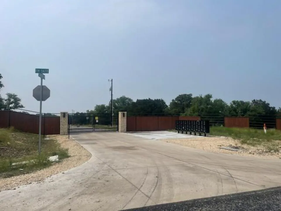 View of street featuring a gate and traffic signs
