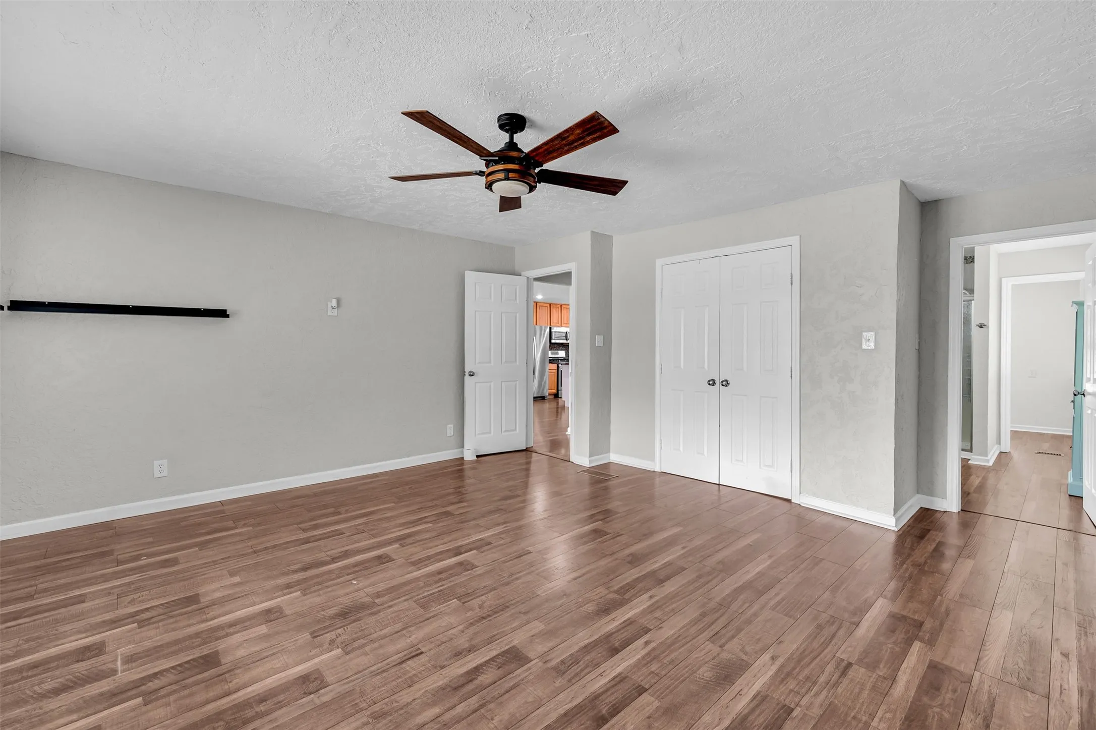 Unfurnished bedroom with wood finished floors, a textured ceiling, a ceiling fan, and a closet