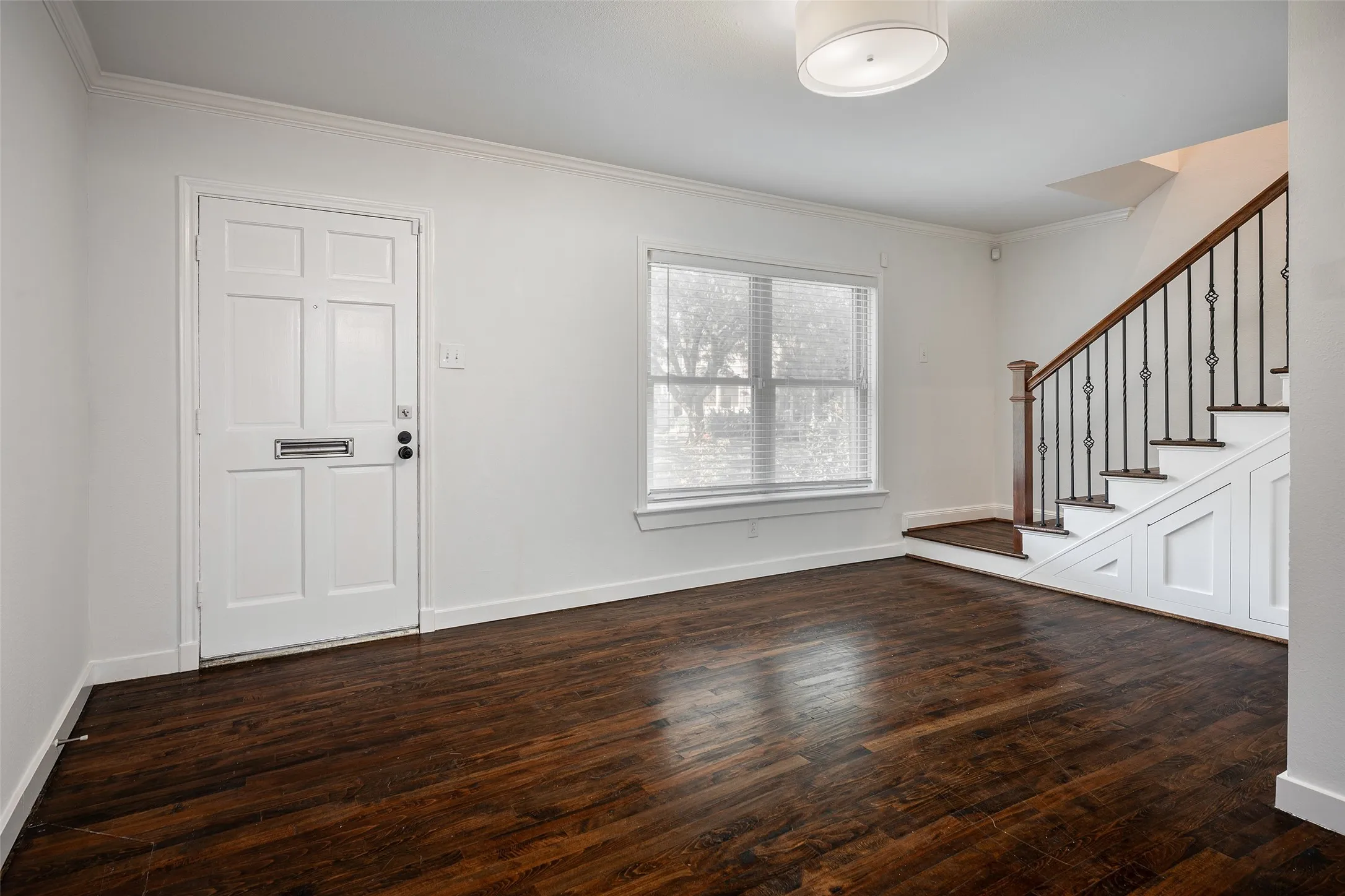 Living room with hardwood floors. Stairs lead to  bedrooms.