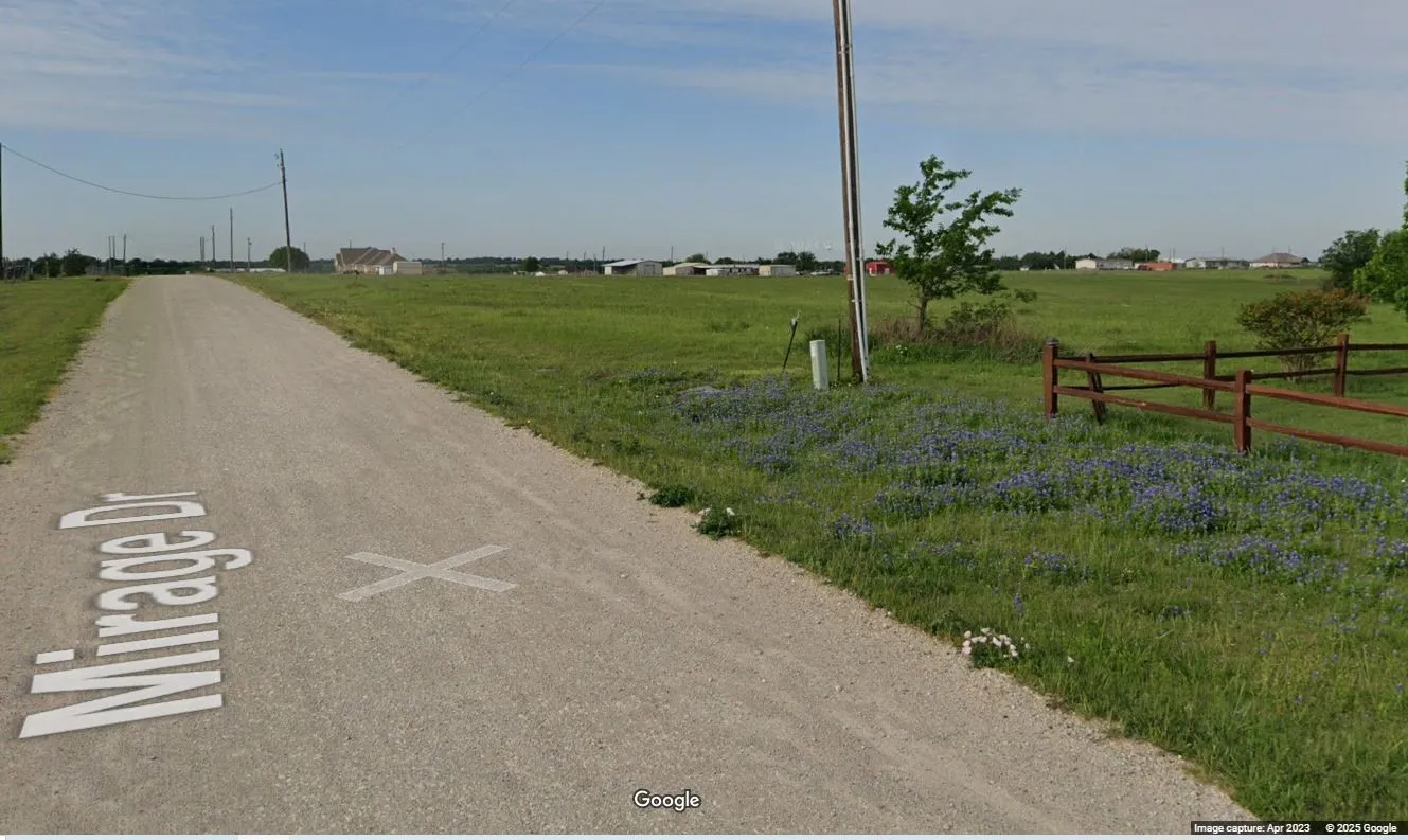 Per Google Street View (April 2023)  Gravel road with a rural view looking from the northeast corner of the property
