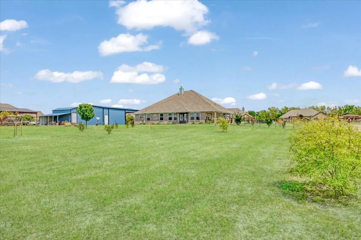 View across back yard/acreage and back view of workshops