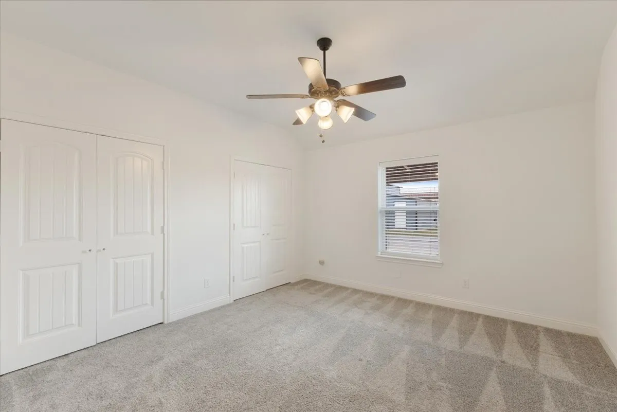 Second bedroom has 2 closets, carpet, ceiling fan