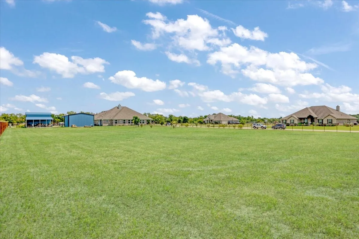 View across back yard looking towards Paige Street; rear view of workshops and home