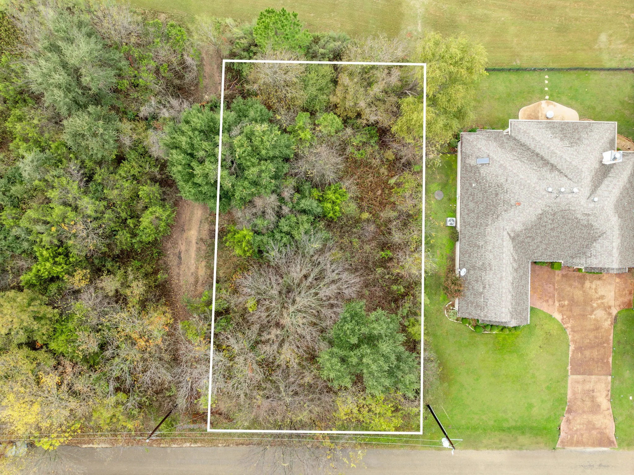 Aerial view of property and surrounding area with property parcel outlined