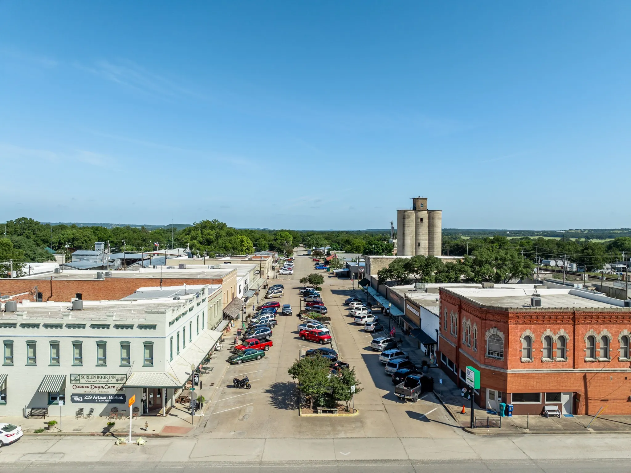 Bird's eye view of a commercial area and a tree filled landscape
