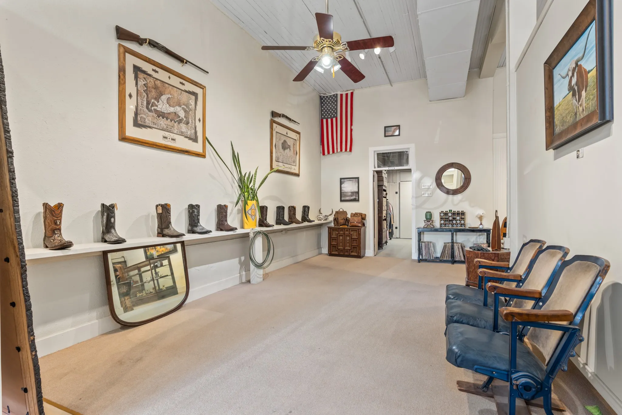 Sitting room with carpet floors, ceiling fan, a wooden ceiling with exposed beams, and a towering ceiling