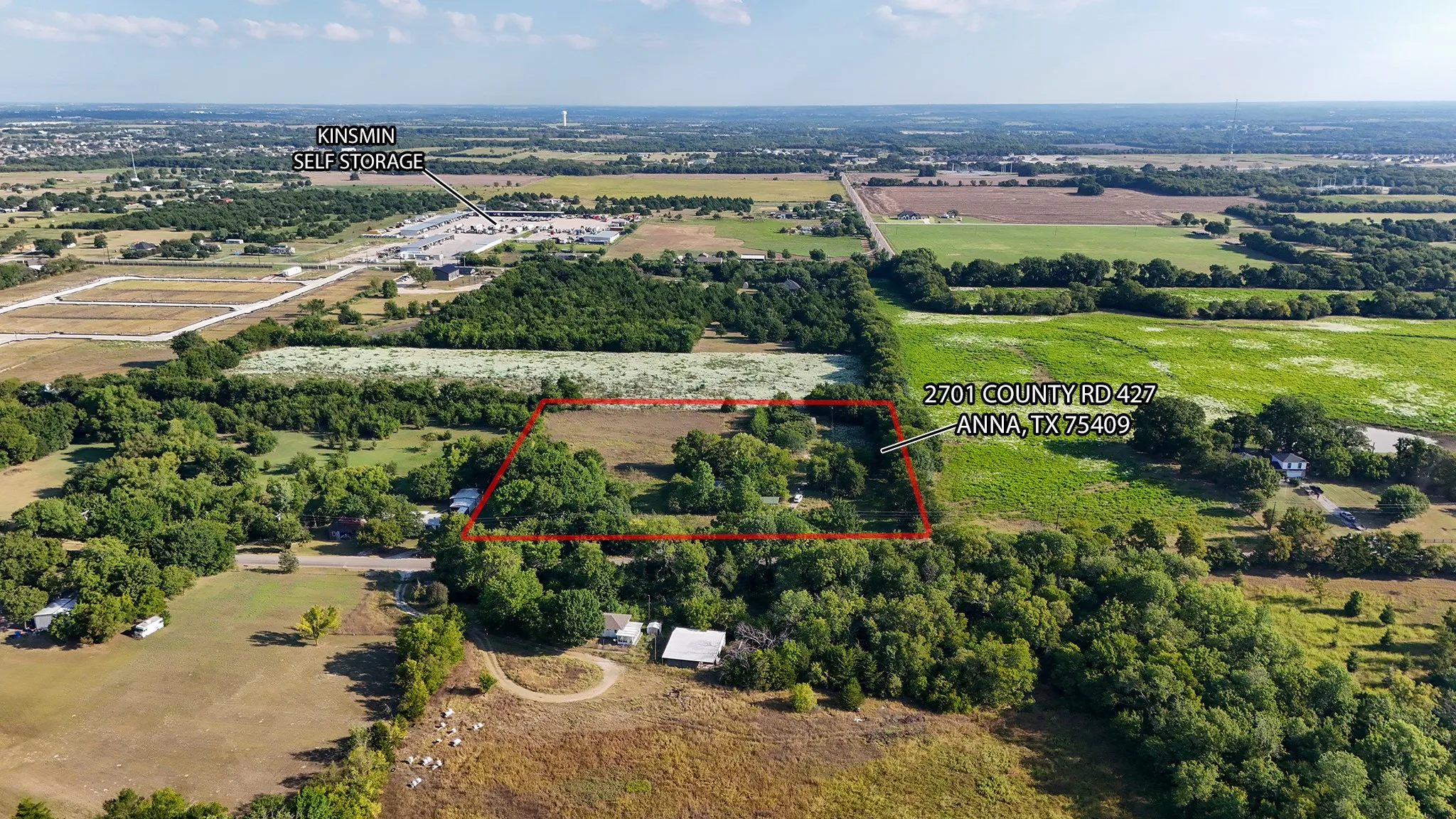 Aerial view of sparsely populated area with property parcel outlined