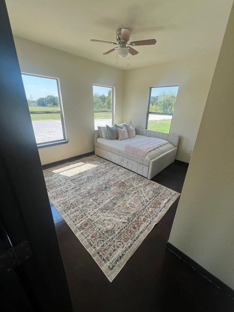 Bedroom with multiple windows and a ceiling fan