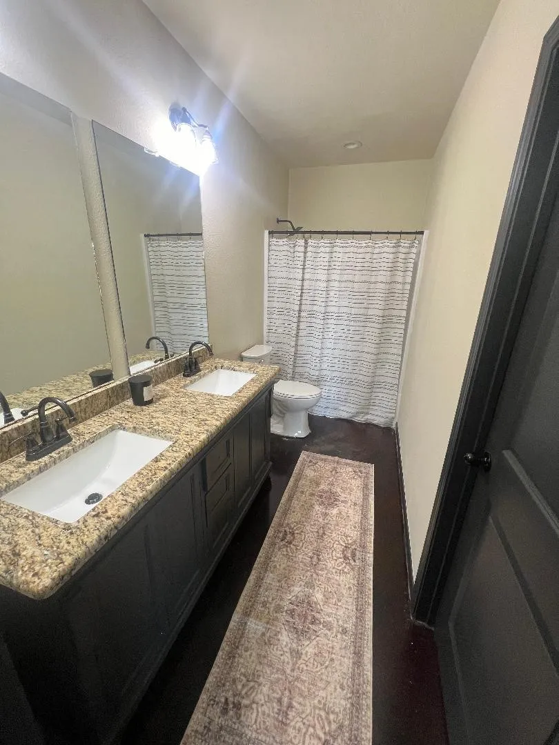 Bathroom with double vanity and toilet
