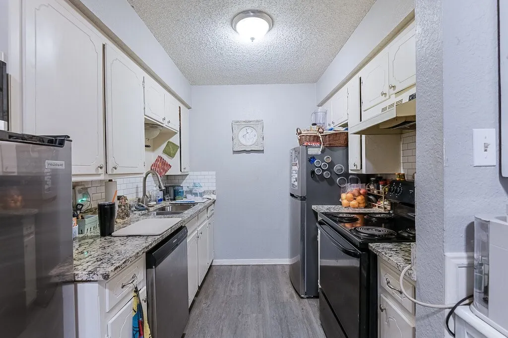 Right Unit Kitchen featuring black electric range, light wood finished floors, white cabinets, a textured ceiling, and dishwasher