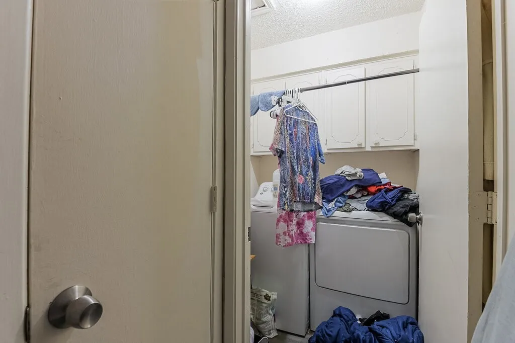 Right Unit Washroom featuring cabinet space, independent washer and dryer, and a textured ceiling