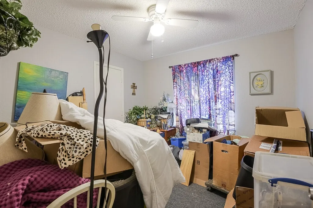 Right Unit Bedroom with a textured ceiling, carpet flooring, and a ceiling fan