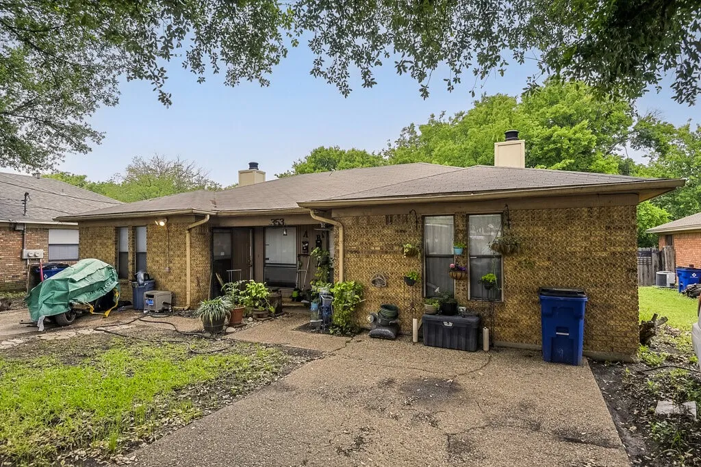Front view of house featuring a chimney, brick siding, and a patio​​‌​​​​‌​​‌‌​‌‌​​​‌‌​‌​‌​‌​​​‌​​ area