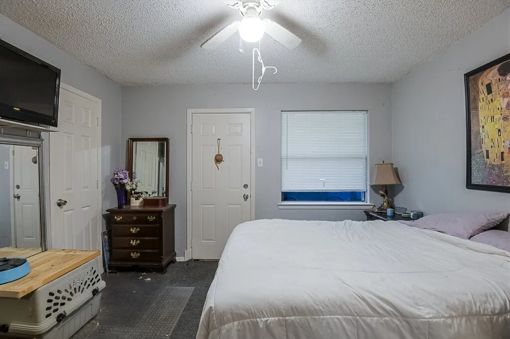 Right Unit Bedroom with a textured ceiling, ceiling fan, and dark carpet