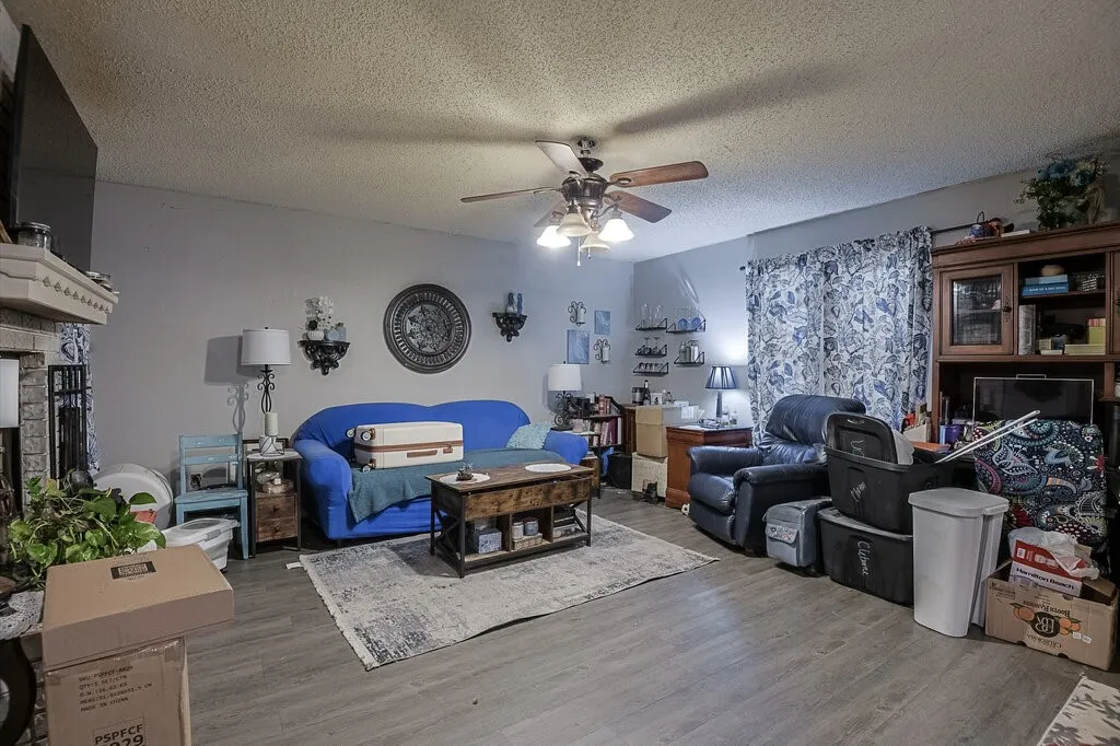 Right Unit Living area featuring a textured ceiling, wood finished floors, a fireplace, and a ceiling fan