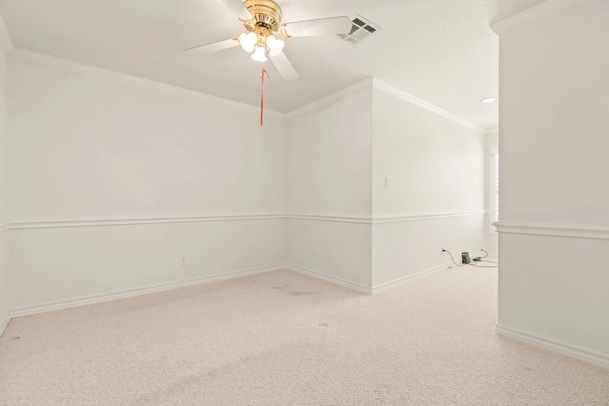 Spare room with crown molding, light colored carpet, and a ceiling fan