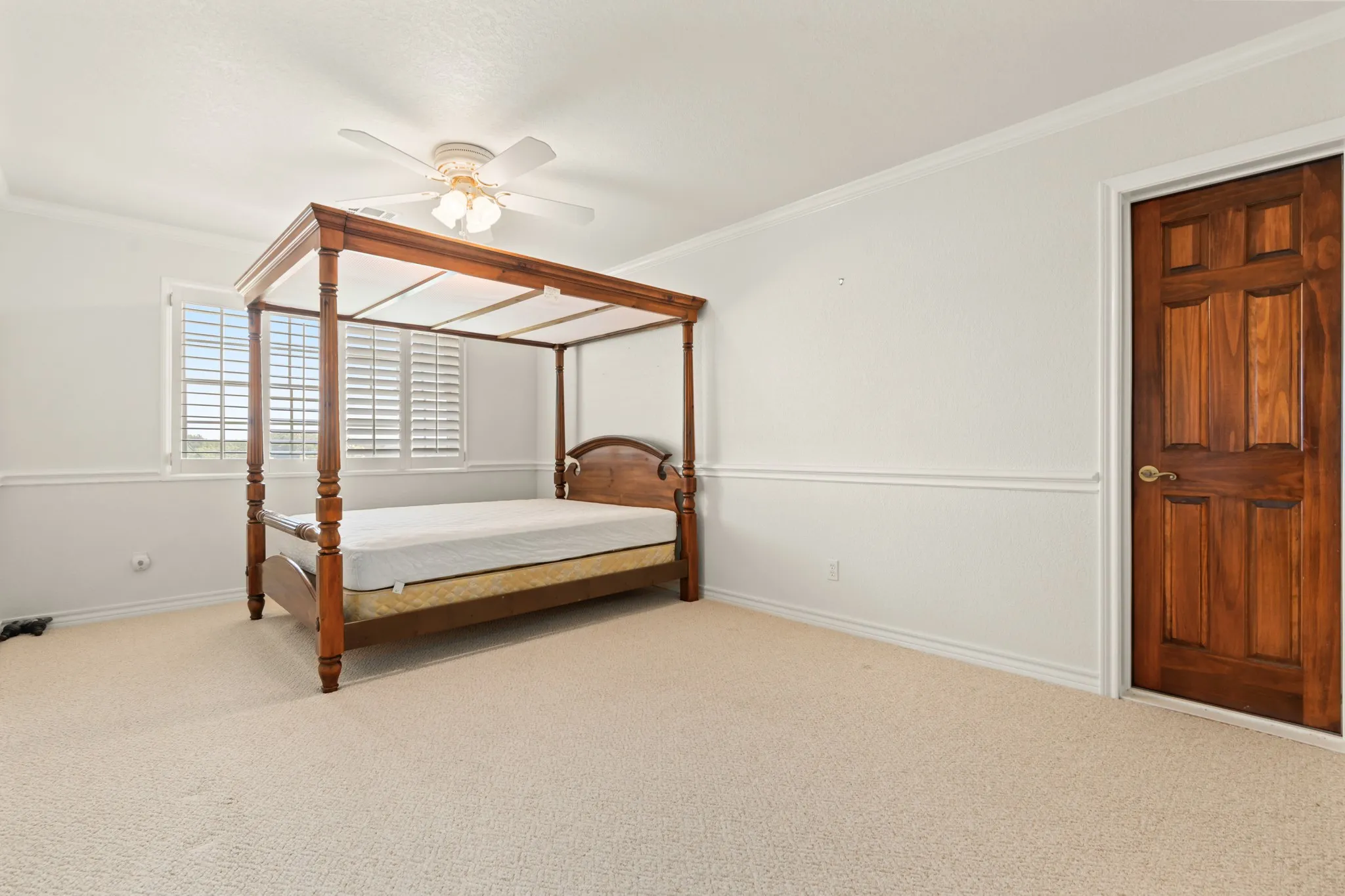 Carpeted bedroom featuring ornamental molding and ceiling fan