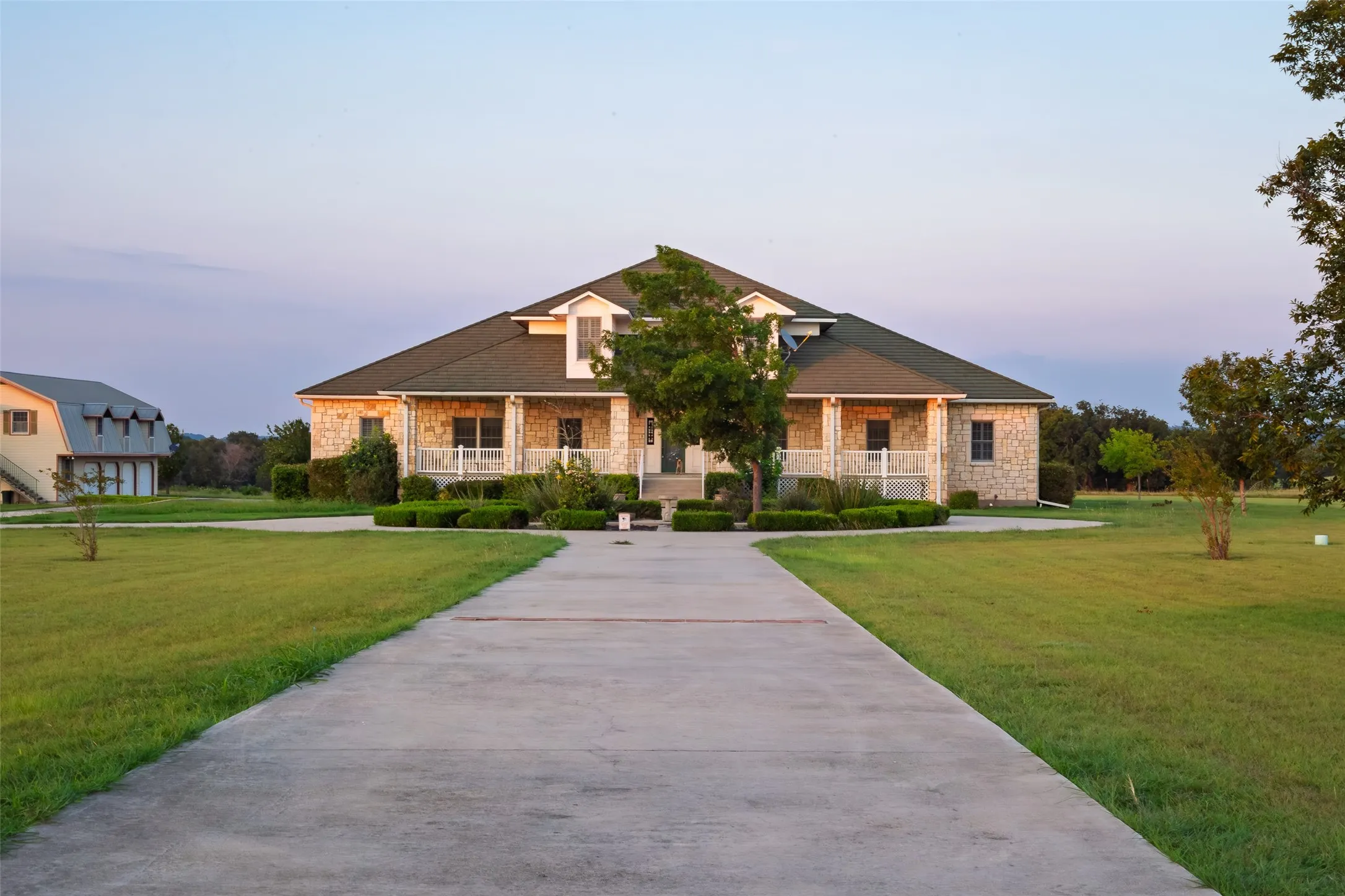 Craftsman-style house with stone siding, covered porch, and a lawn