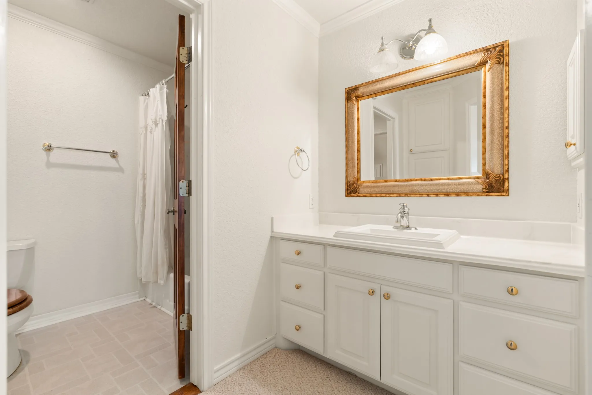 Bathroom featuring ornamental molding and vanity