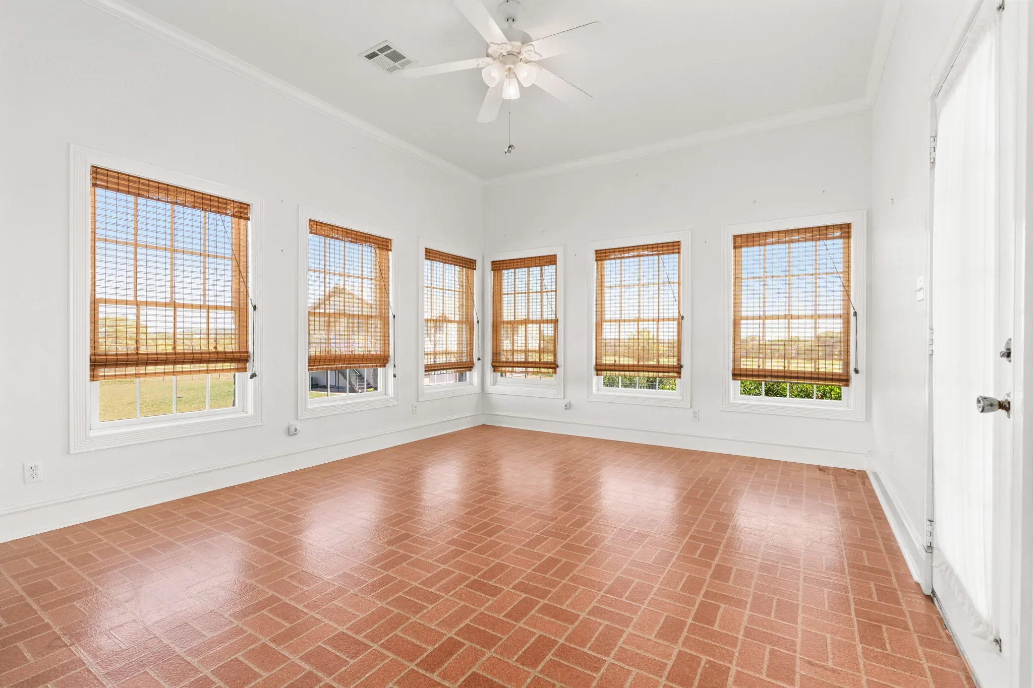 Spare room with ornamental molding, brick patterned flooring, and ceiling fan
