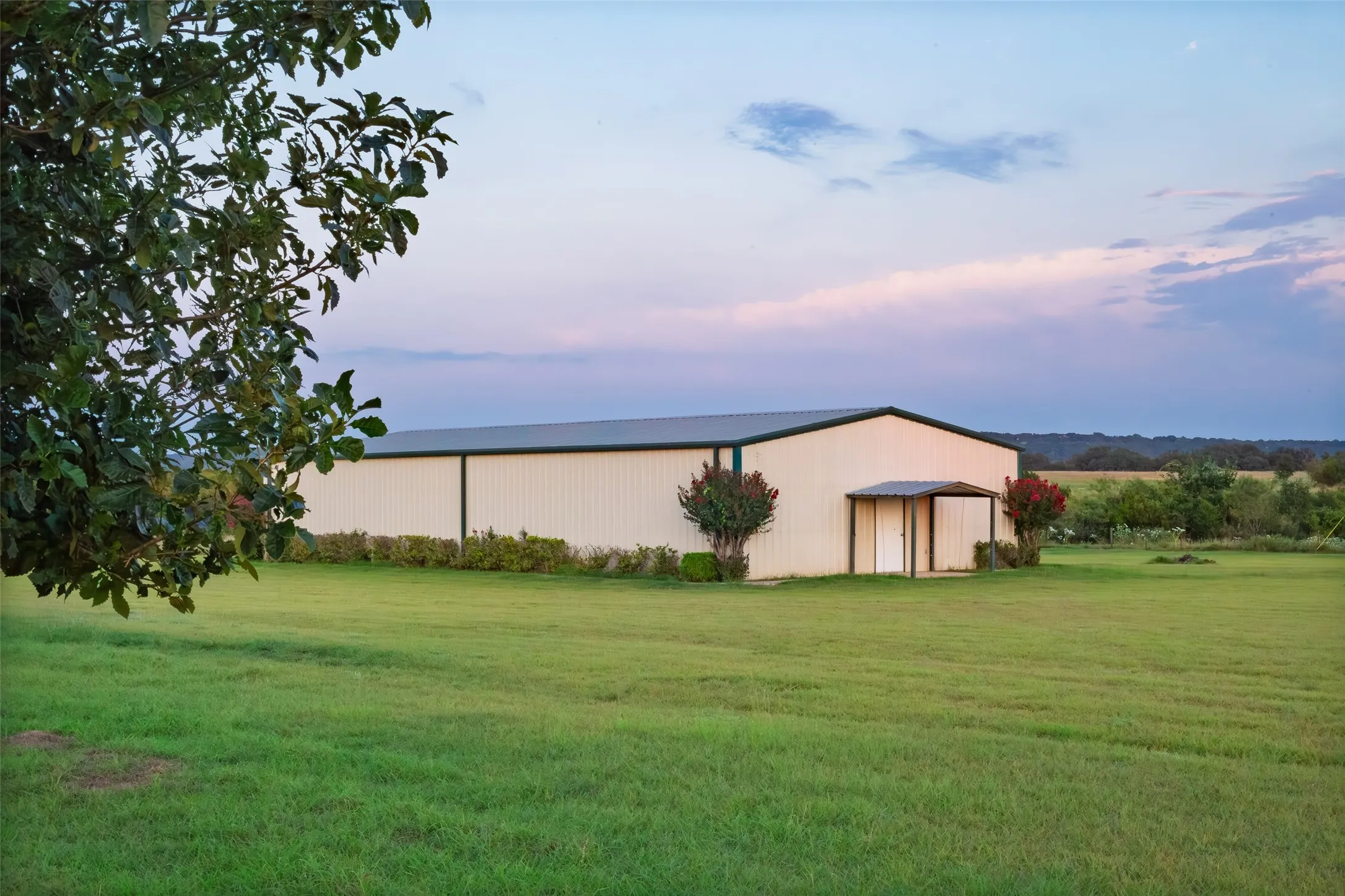 View of green lawn featuring an outbuilding and a pole building