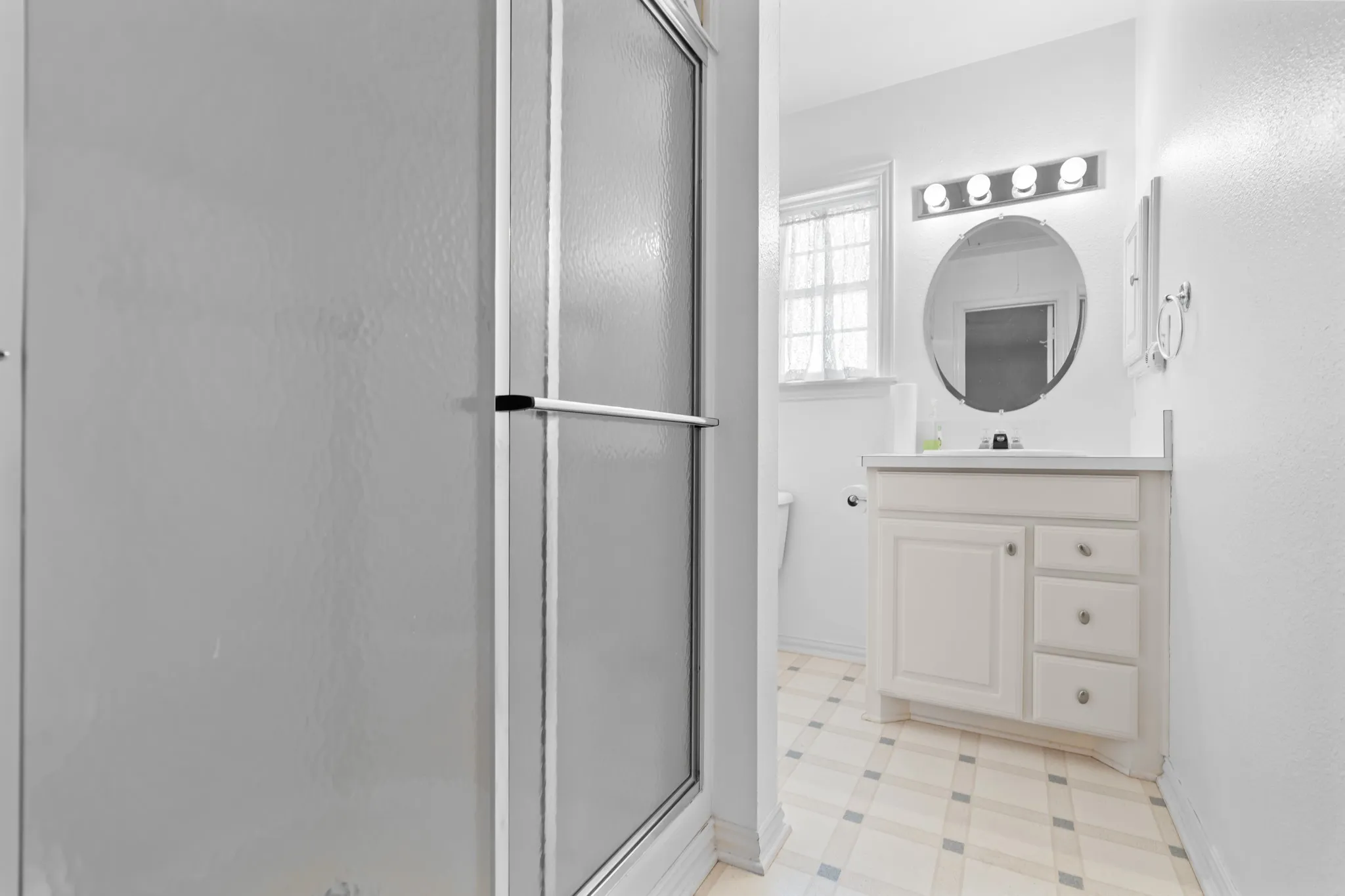 Full bathroom featuring a stall shower, vanity, and light flooring