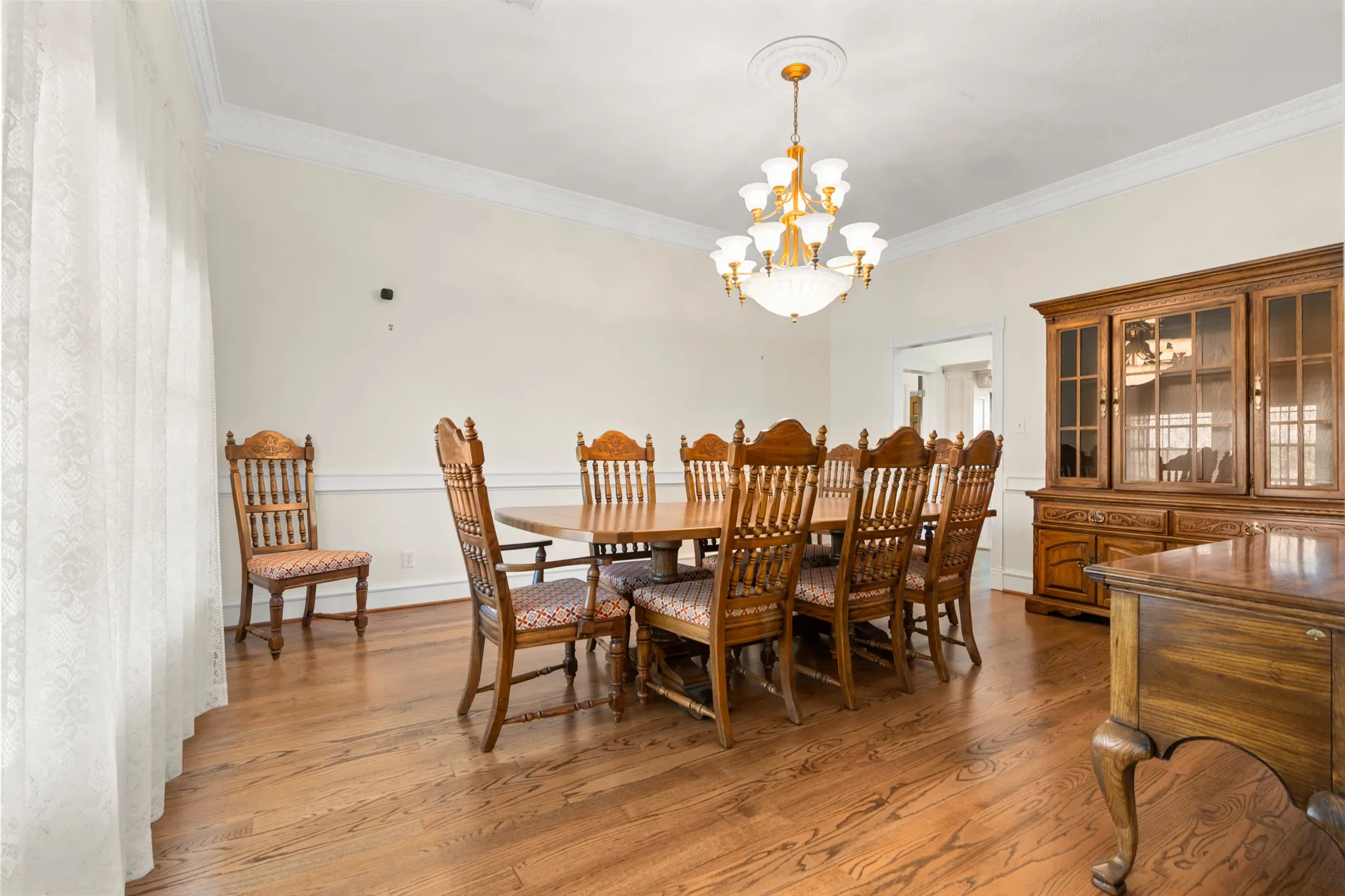 Dining space featuring ornamental molding, light wood-style floors, and a chandelier