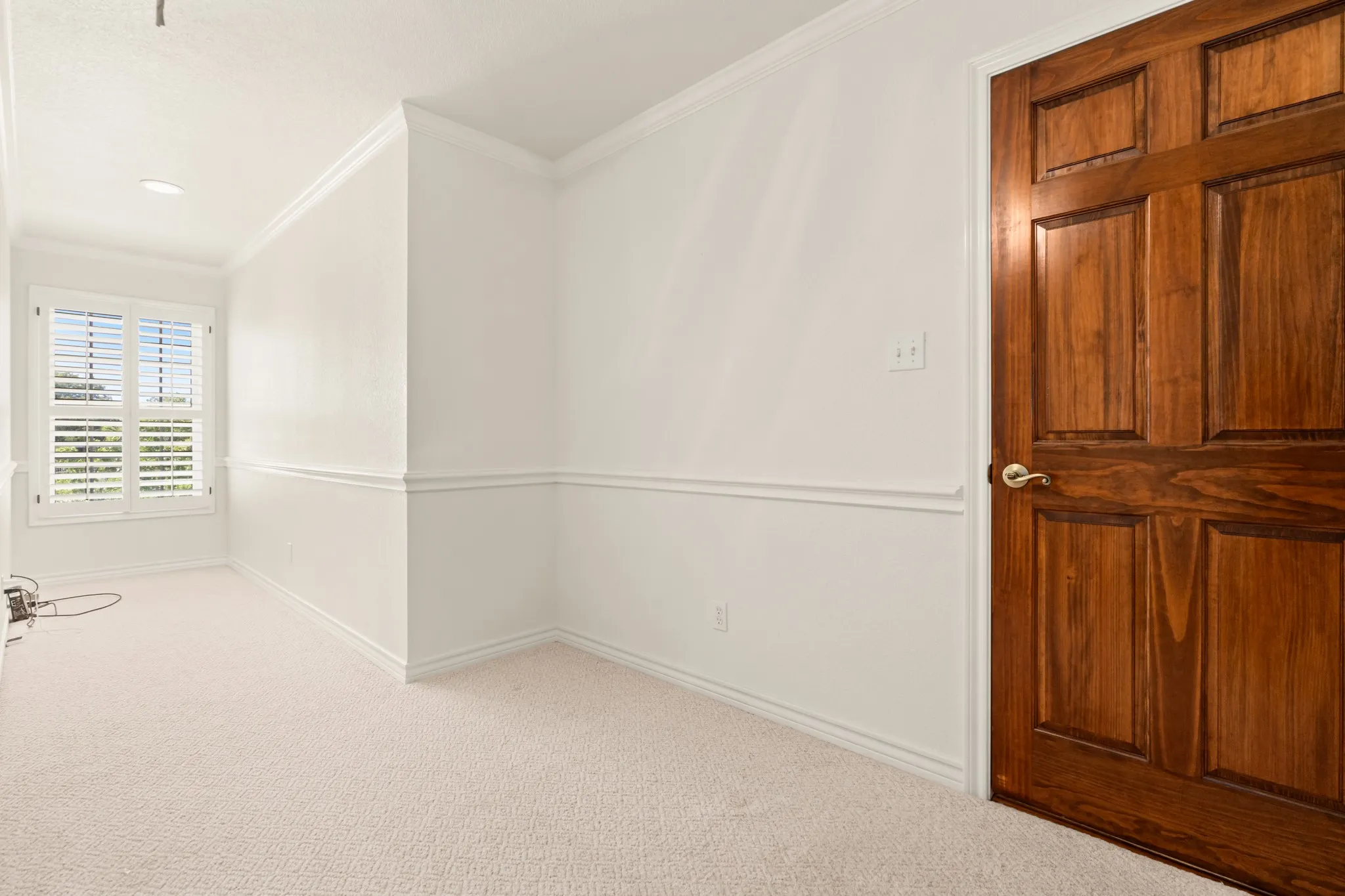Carpeted empty room featuring baseboards and crown molding