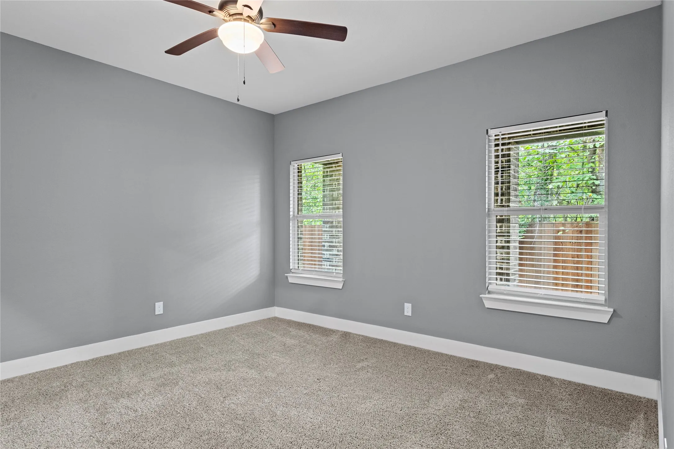 Spare room featuring carpet and ceiling fan