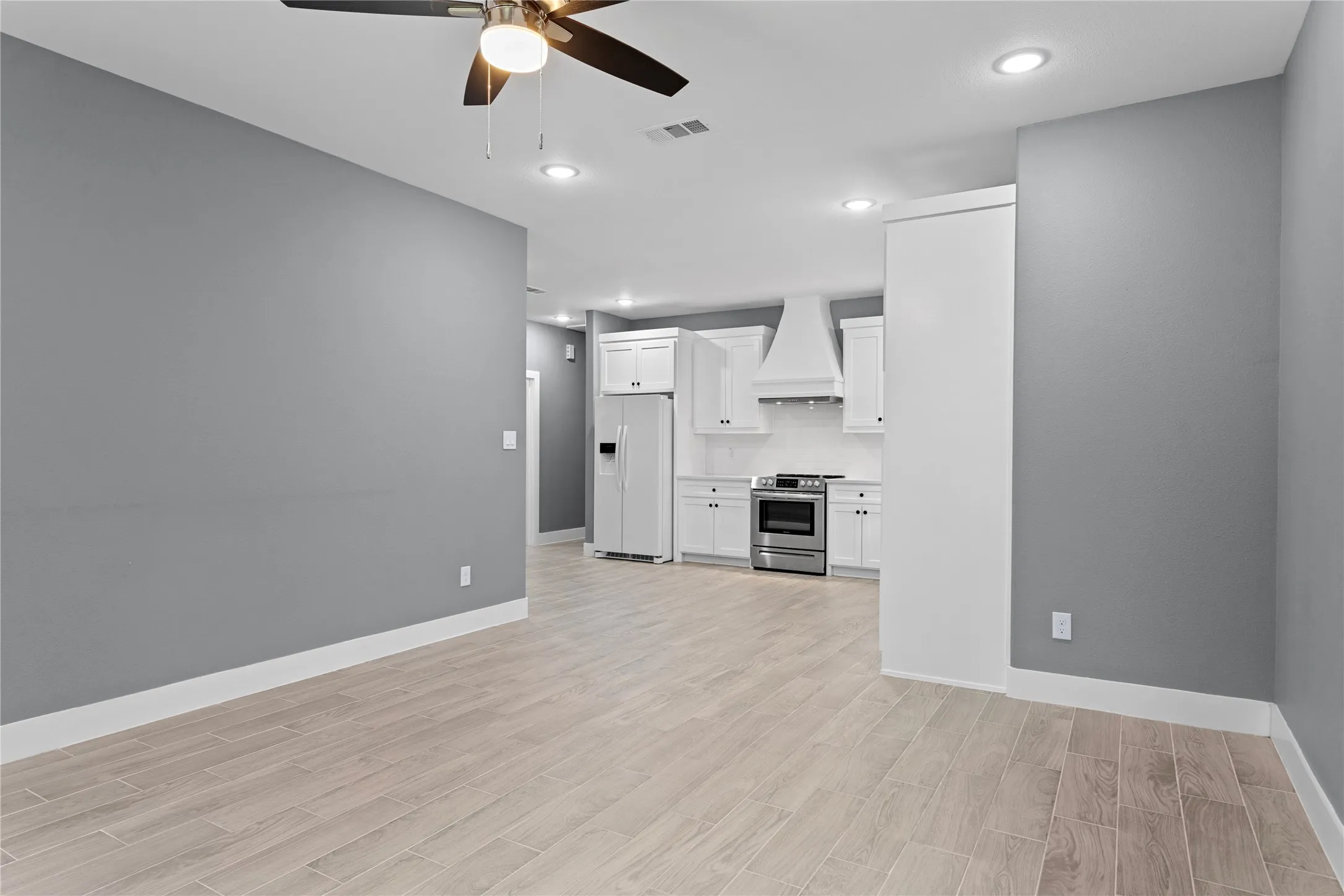 Unfurnished living room featuring light wood-style flooring, recessed lighting, and a ceiling fan