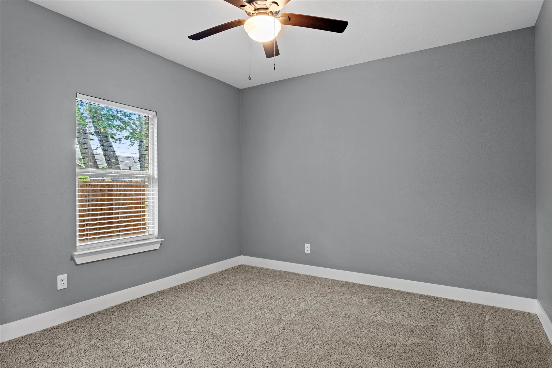 Empty room with carpet floors and a ceiling fan